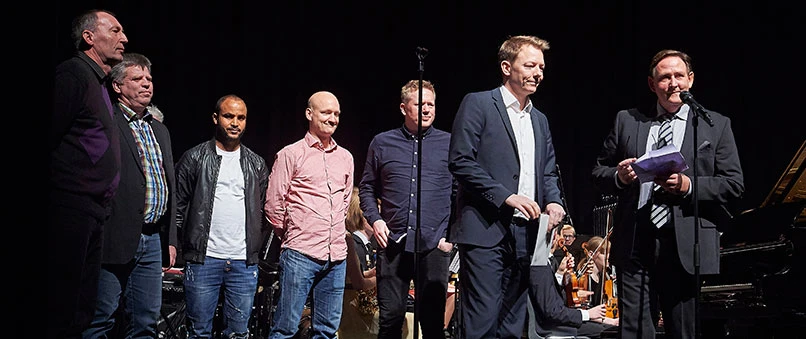 Formand for Sparekassen Sjælland Fonden Svend-Aage Dreist Hansen (til højre) og filialdirektør i sparekassens afdeling i Ringsted Mads Wallin (nummer to fra højre) var på scenen i Ringsted Kongrescenter for at overrrække 50.000 kr. til de frivillige ledere i Benløse Idrætforening.
